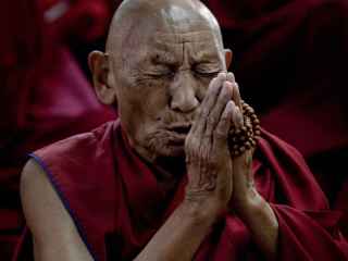 Palden Gyatso estuvo 33 años preso en las cárceles chinas de Tíbet. Escapó cruzando el Himalaya a pie y denunció las torturas sufridas en su libro 'Fuego bajo la nieve'. En la imagen, reza en el monasterio de Namgyal Monastery, en Dharamsala,  por sus compatriotas inmolados (143 hasta la fecha).