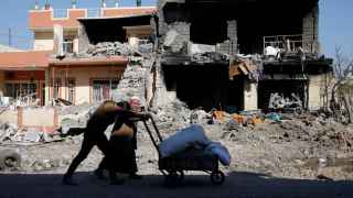 Dos hombres pasan ante un edificio destruido por los enfrentamientos en Mosul.